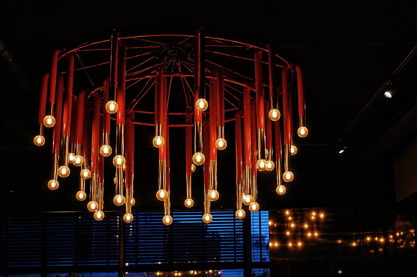 Red chandelier lights over the Café Momus terrace at night