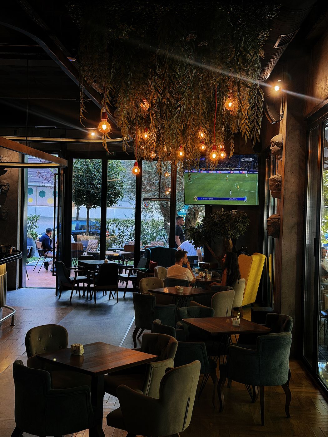 Interior of Café Momus with plants and warm lighting