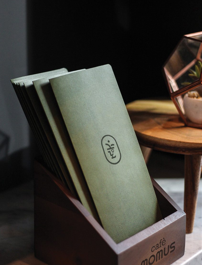 Café Momus menus in a wooden holder inside the café
